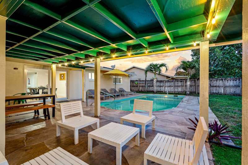 The Game House: Covered patio with picnic table and loungers, beside the pool