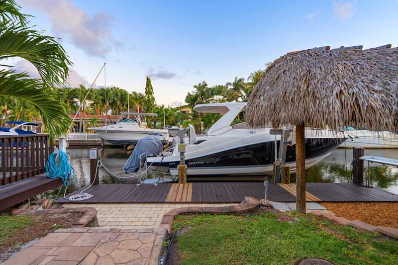Canal House: Dock and boat lift on the canal, beside the tiki hut