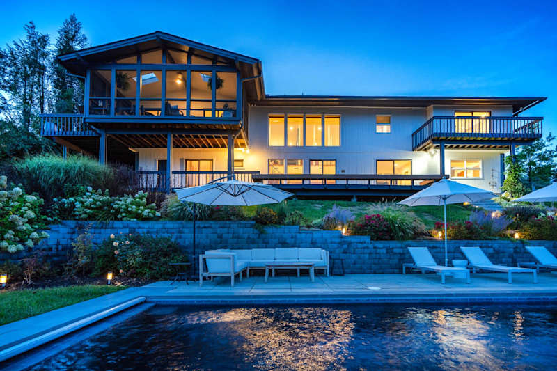 Hudson House: Back of the house at dusk with the heated pool and screened porch