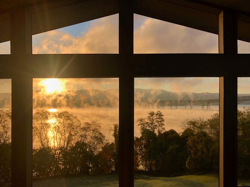 Hudson House: Sunrise over the misty river through the tall front windows