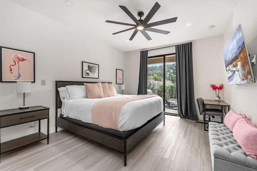 The Arcade House: Bedroom with king bed, desk and sliding doors to the patio