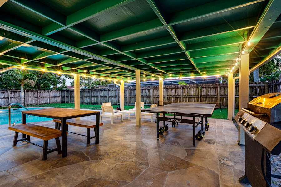 The Game House: Picnic table and ping pong on the covered patio, beside the grill