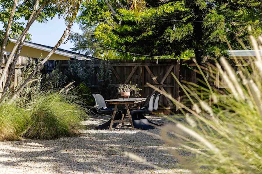 Sombra Cottage: Backyard area showing the lush landscape and seating area