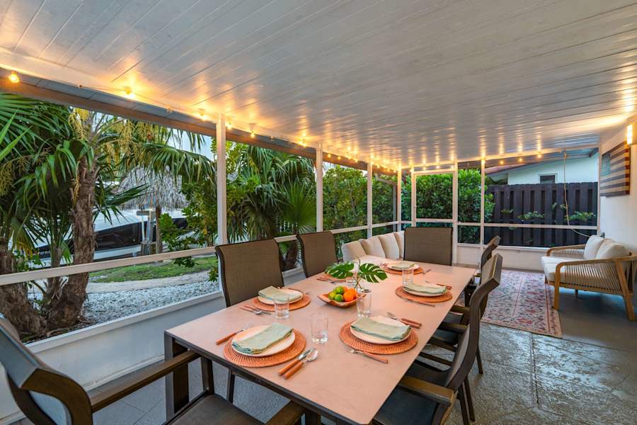 Canal House: Covered porch dining for six, lit with string lights