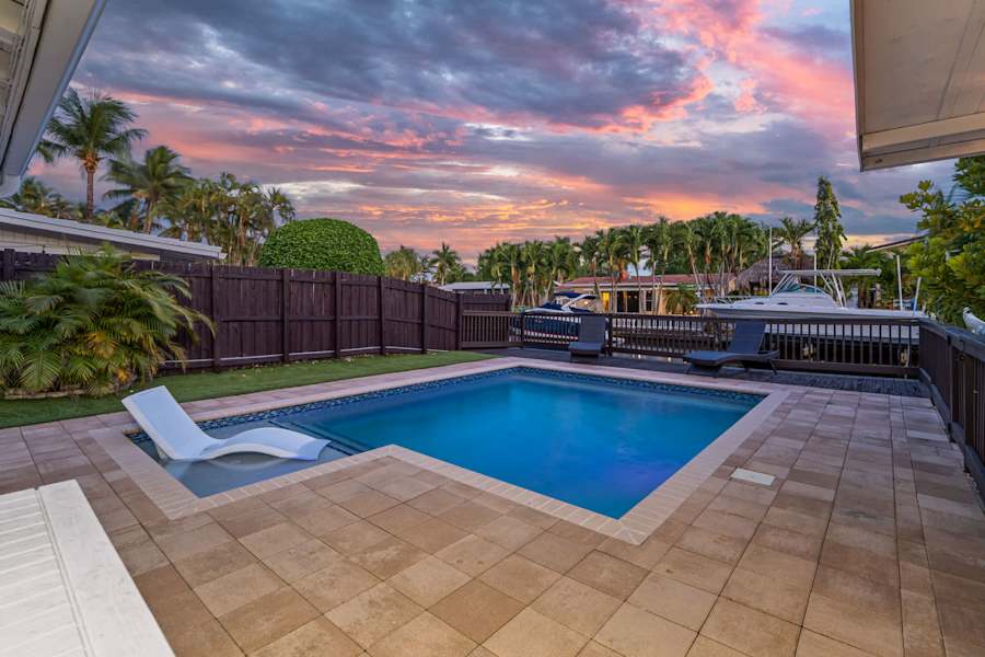 Canal House: Pool and sun lounger at dusk, with the canal beyond