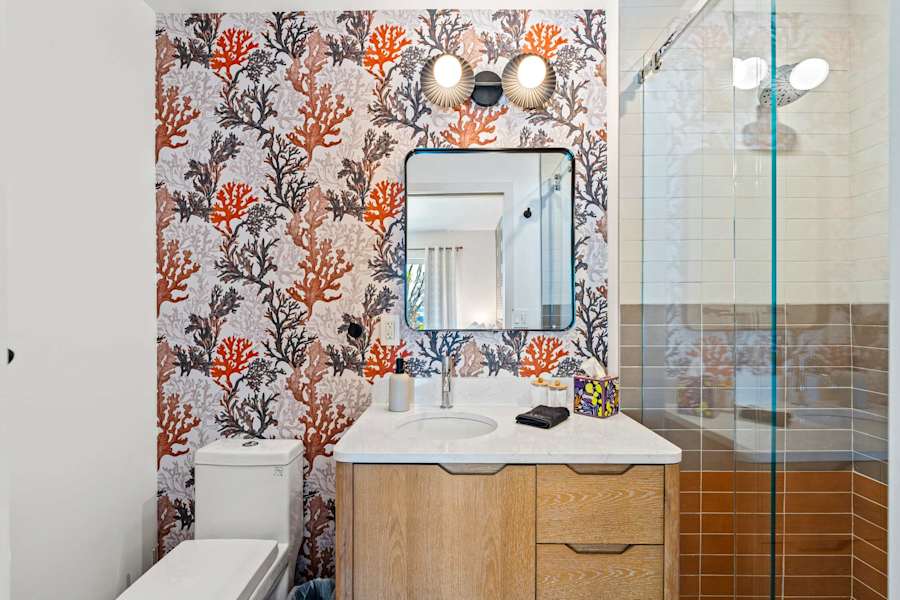 Mangrove Manor: Guest bathroom with walk in shower and coral papered feature wall