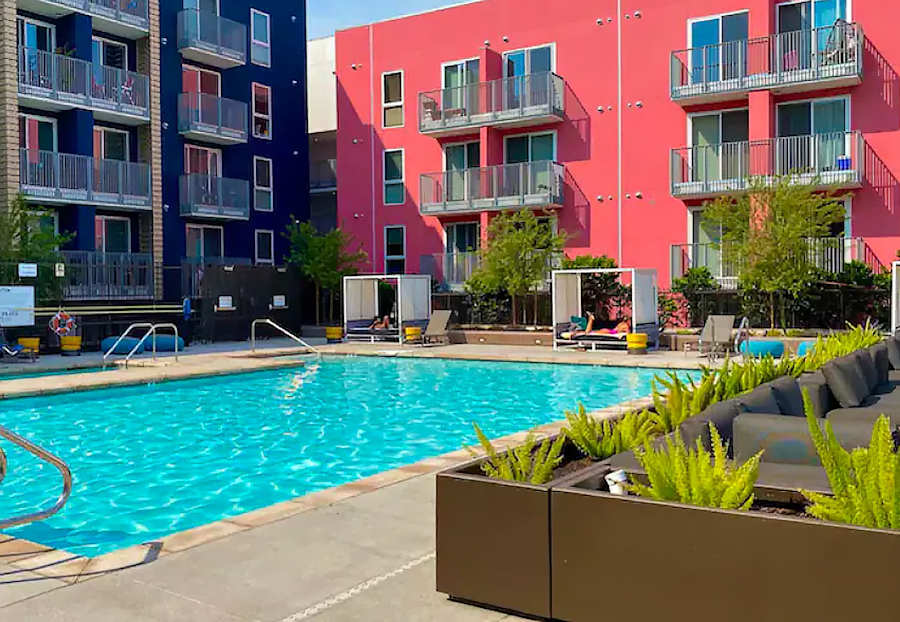 A swimming pool with a pink building in the background