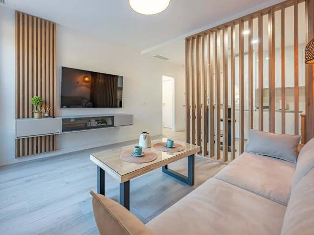 Salón con TV y celosía de madera