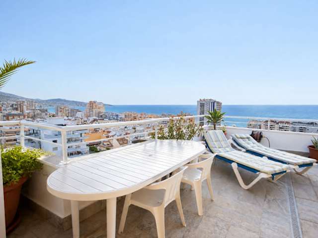 Comedor exterior y tumbonas frente al mar