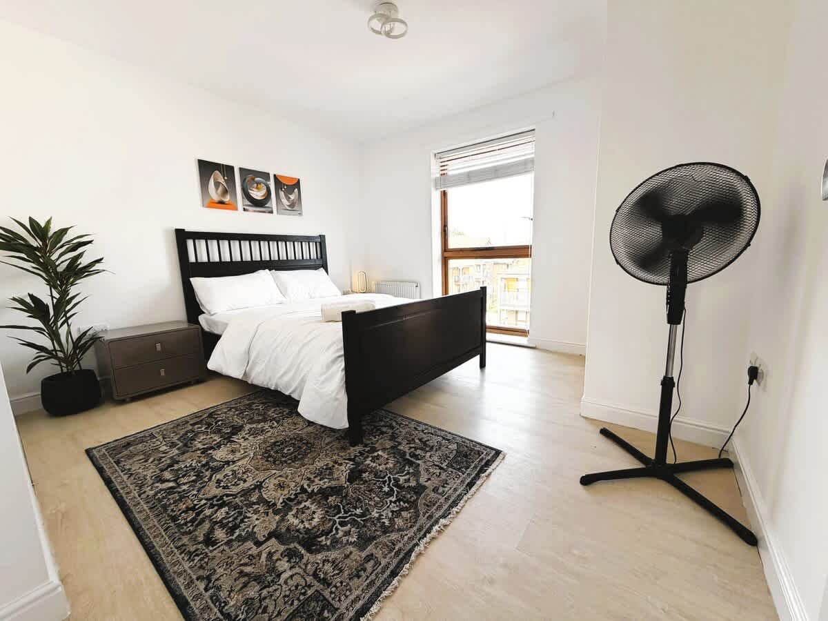A double bedroom at the Croydon apartment, with a balcony door letting in daylight