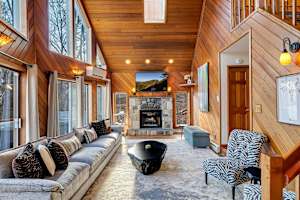 Living Room: Vaulted ceilings, stunning views, and a cozy gas fireplace create the perfect backdrop for relaxation. Kick back on the comfortable couch, enjoy the Roku TV, and stay comfortable with the split system for year-round climate control!