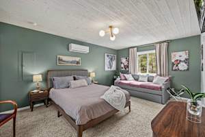 Unwind in the master bedroom, featuring a plush queen bed, warm bedside lighting, and a stylish dresser that adds both charm and convenience. The perfect retreat for a restful night.