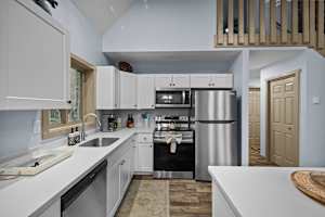 Modern kitchen featuring stainless steel appliances, including a fridge, microwave, electric stove and oven, along with sleek white cabinetry—perfect for whipping up a delicious meal.