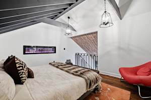 Wake up under the beams in the open loft king — the fireplace sits at the foot of the bed and the whole house is quiet below you.
