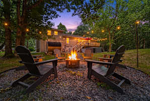 Everything you came for --- fire pit, private hot tub, barrel sauna, and a spacious deck, all glowing at twilight in your own Poconos backyard retreat.
