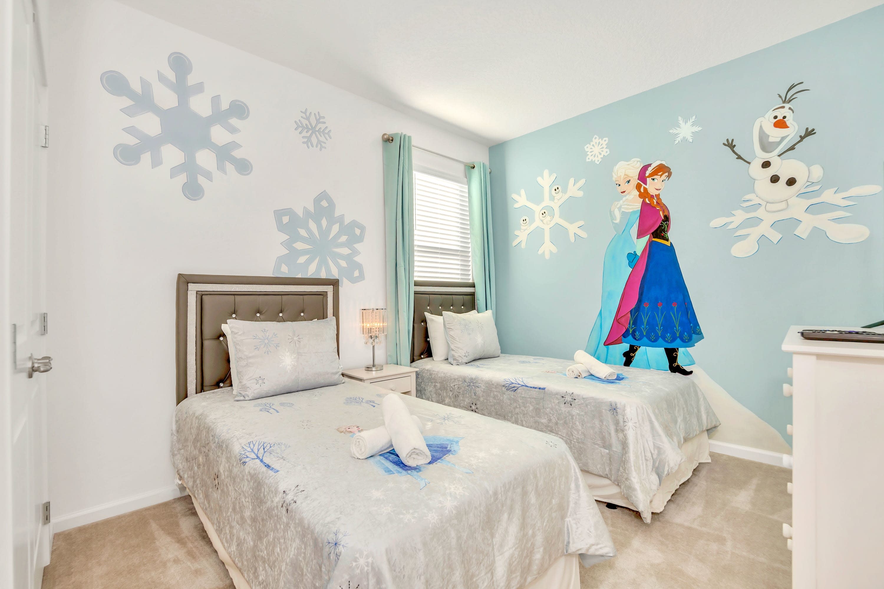 A whimsical Frozen-themed guest bedroom featuring character wall murals
