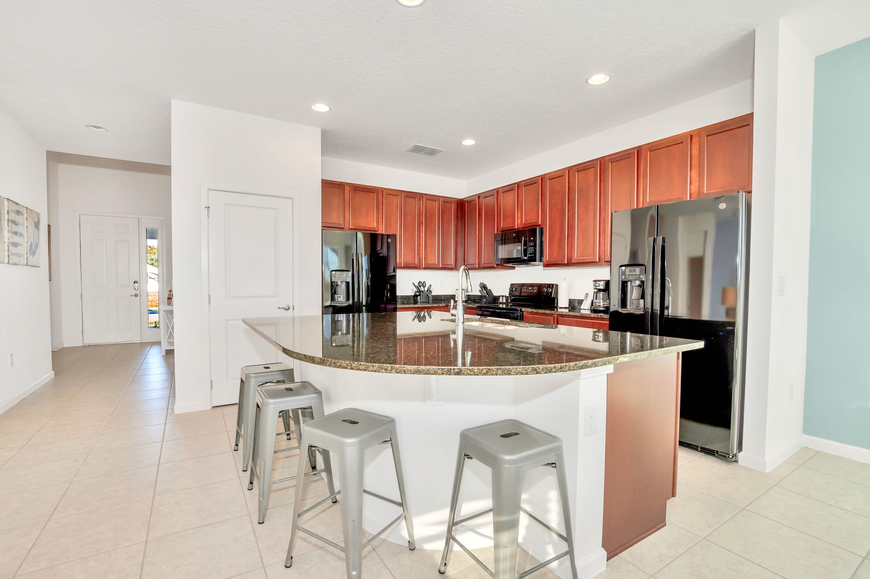 A modern, fully equipped kitchen featuring sleek granite island countertops