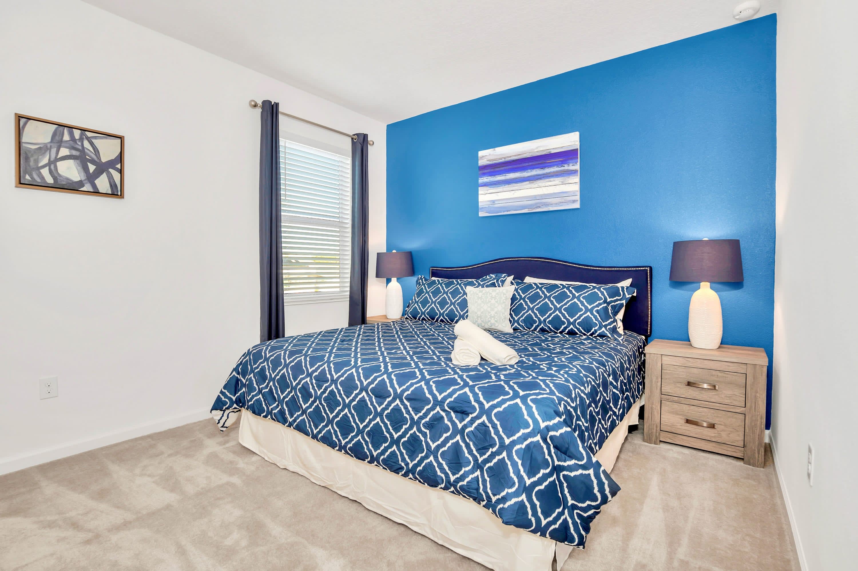 A peaceful guest bedroom featuring crisp white linens and a wall-mounted TV