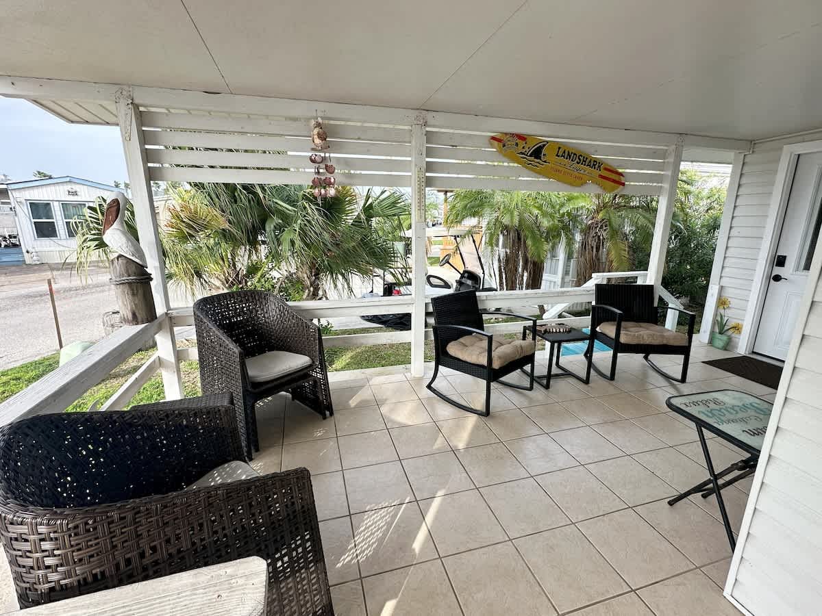 Covered patio with seating: Relax with your morning coffee surrounded by palm trees and coastal breezes.
