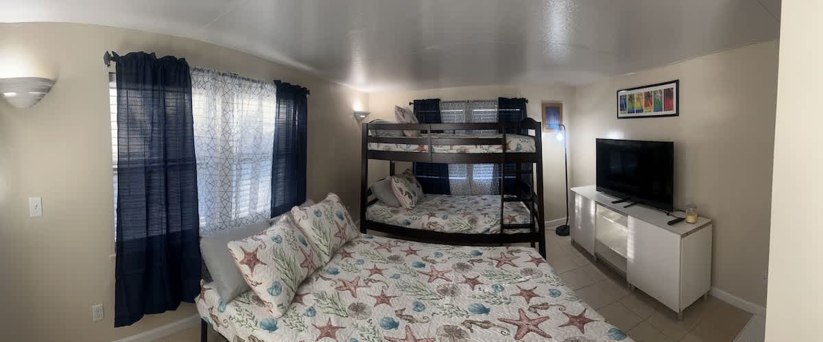 Sleep peacefully in this spacious bedroom featuring a double bed, and a bunk bed with a TV for entertainment.
