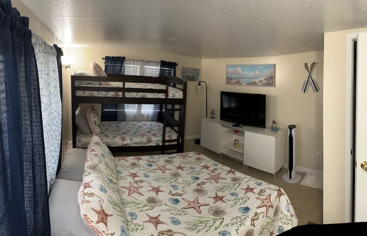 Sleep peacefully in this spacious bedroom featuring a double bed, and a bunk bed with a TV for entertainment.