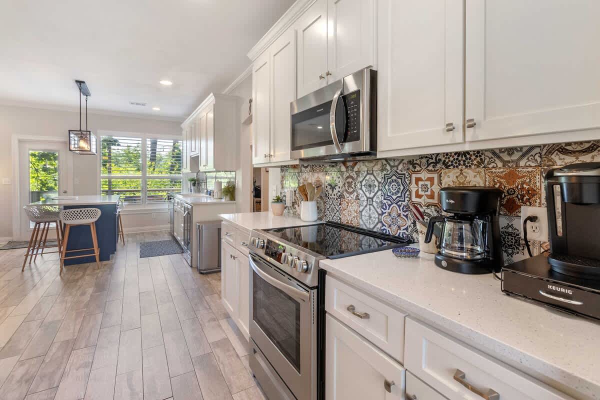 Kitchen: Main floor, drip coffee maker, Keurig, air fryer, Crockpot, toaster oven, blender, cooking utensils, tableware