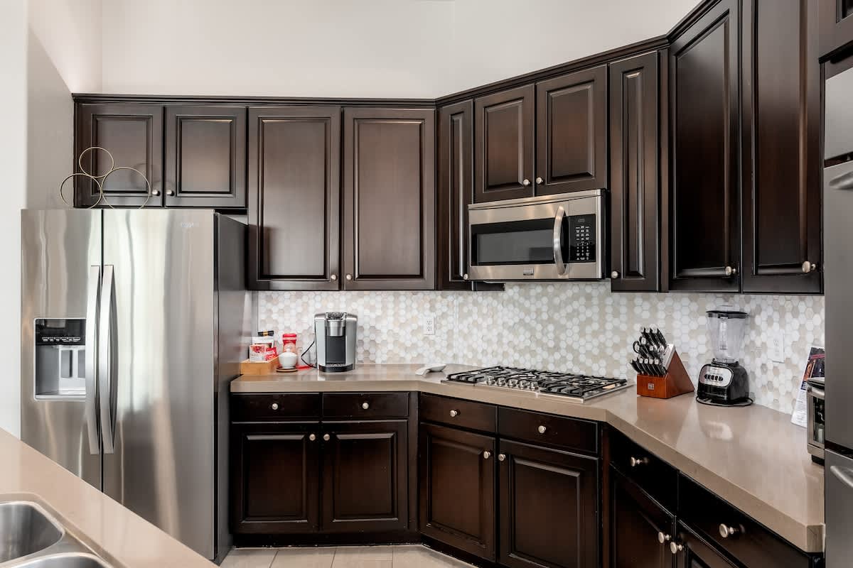 Your fully equipped kitchen invites you to prepare meals with ease, featuring rich cabinetry, modern appliances, and elegant tile backsplash—perfect for gathering over home-cooked favorites.