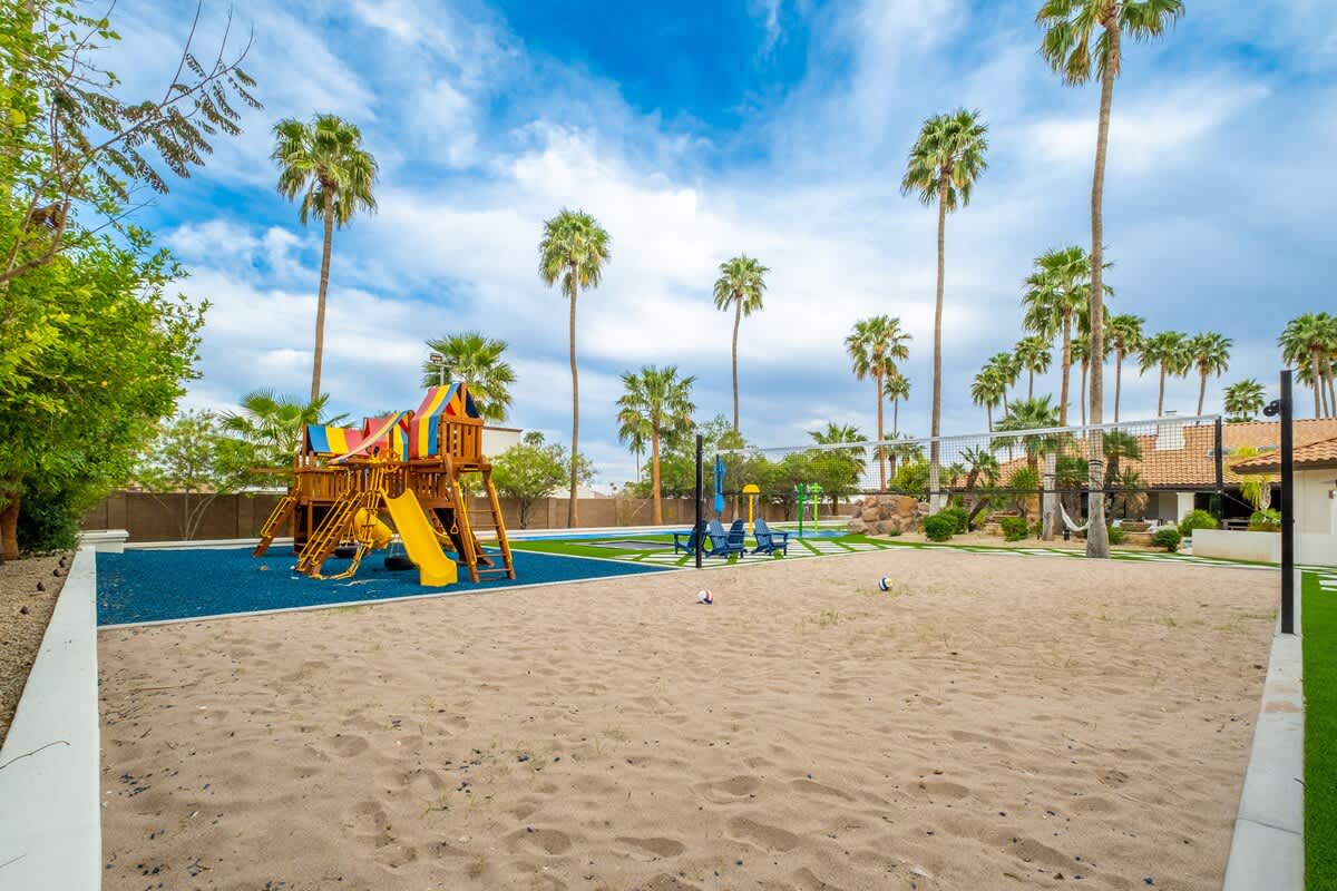 Kids can burn off energy on the colorful play structure, sandy play area, and sports court under swaying palms.
