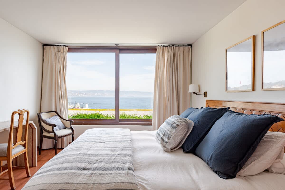 Relax in this serene bedroom with breathtaking ocean views, perfect for unwinding after a day of exploring.