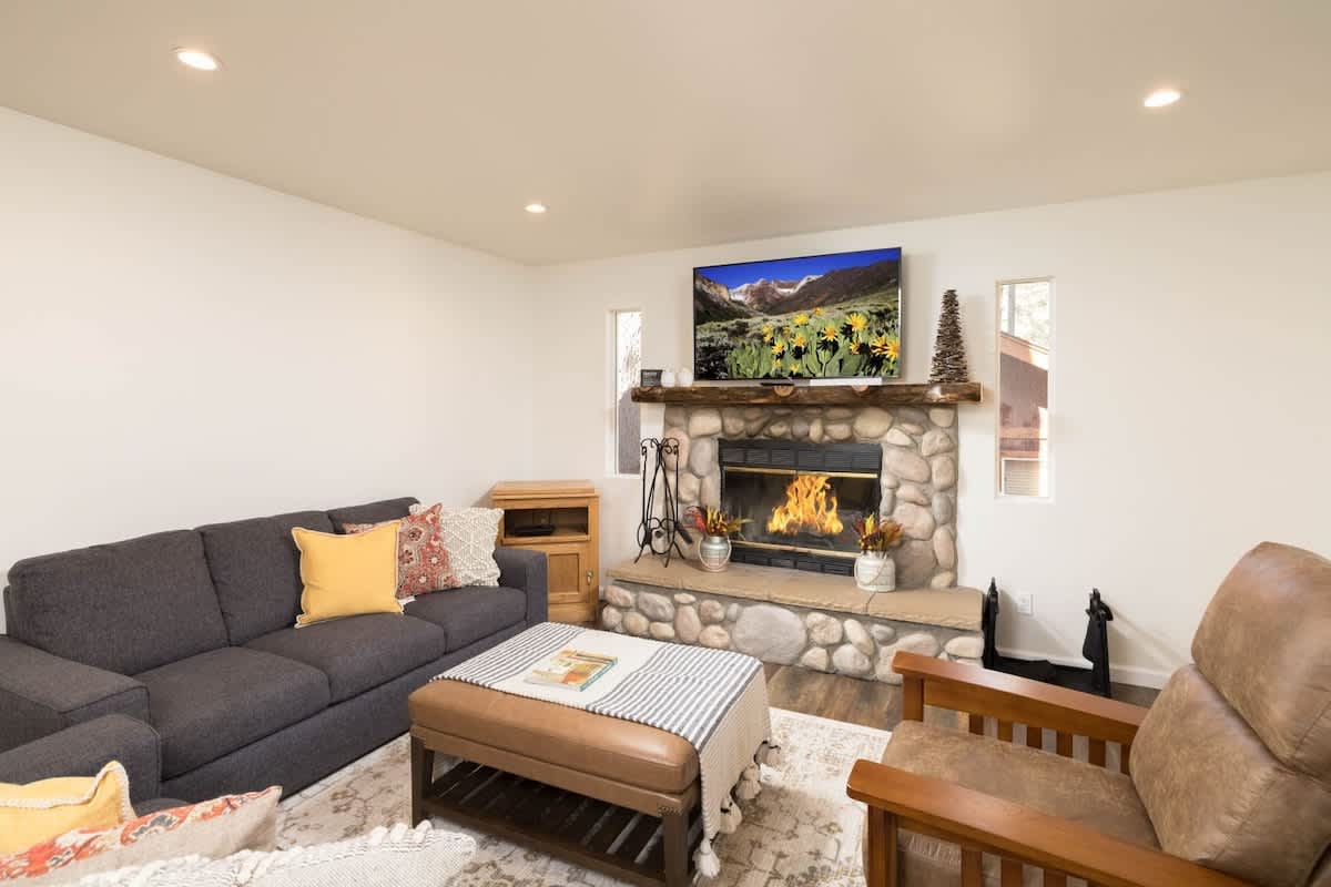 Watch your favorite shows on 55" Roku Smart TV over log fireplace