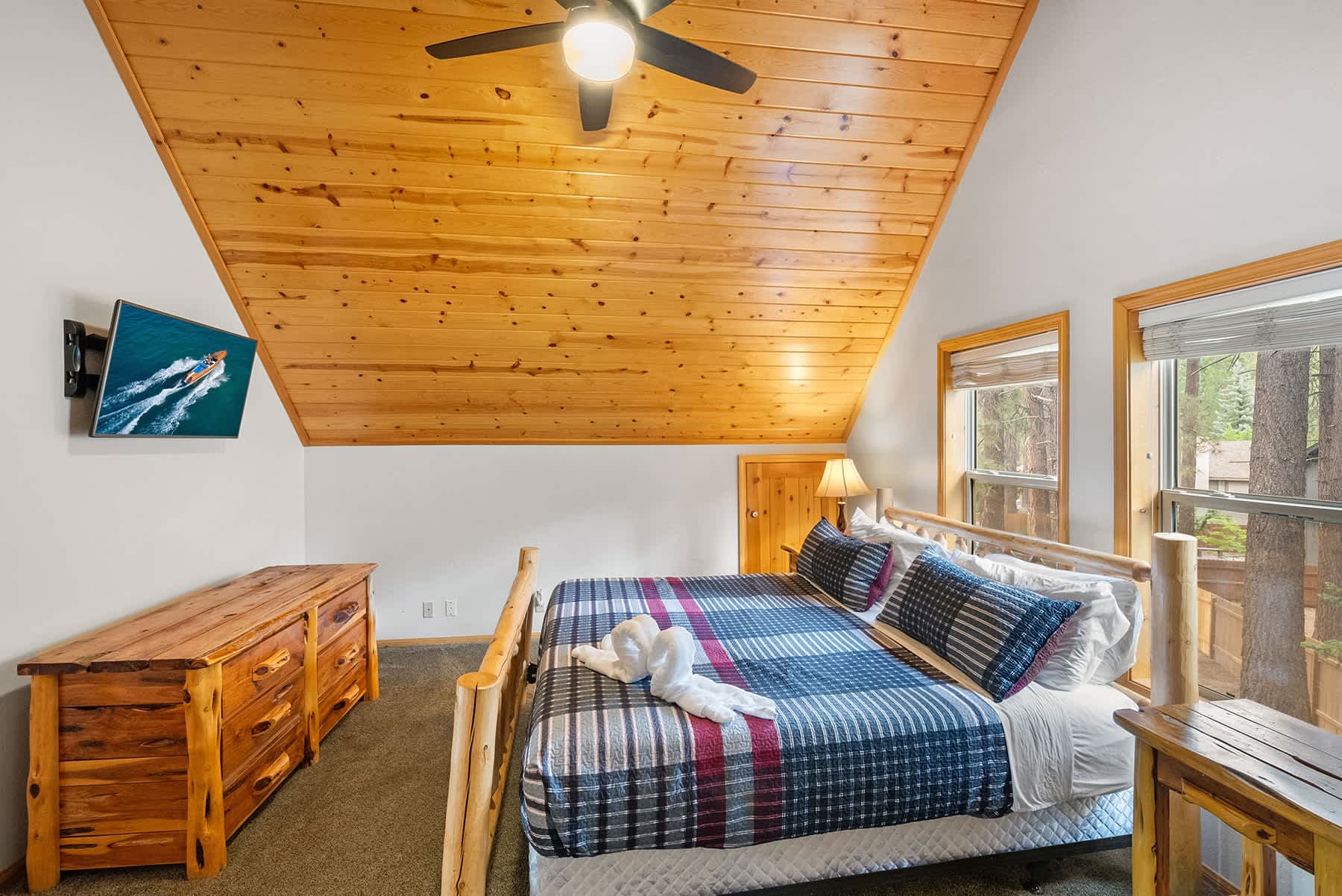Upstairs King bedroom with vaulted pine ceiling and TV.