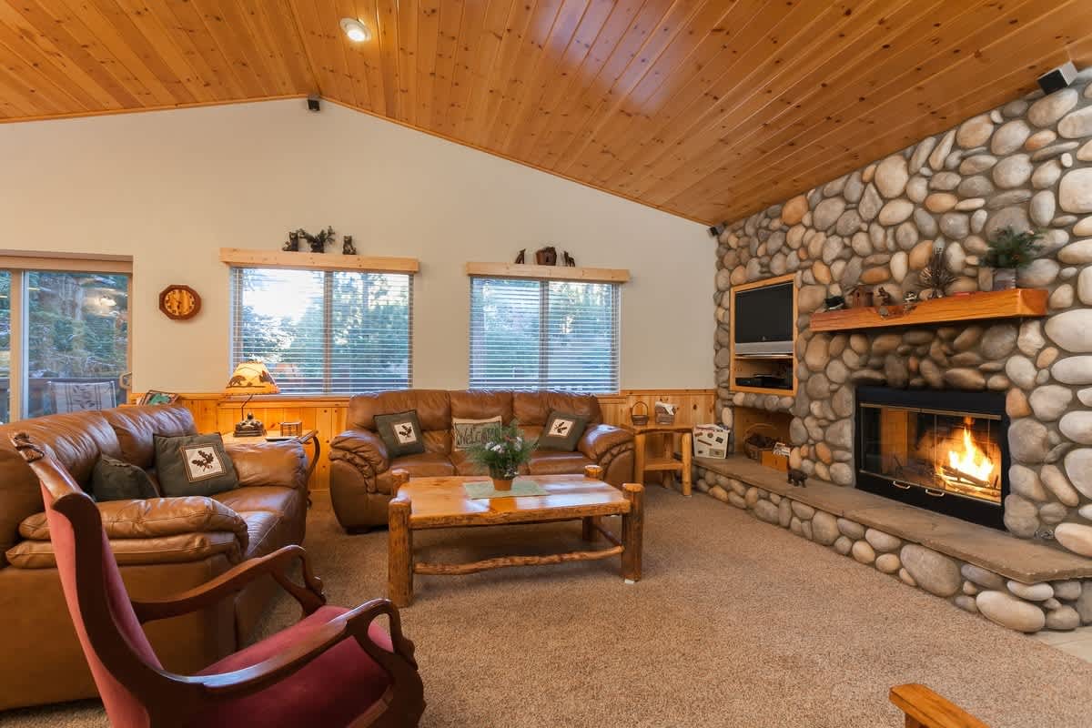 Living room with river rock gas fireplace and Smart TV