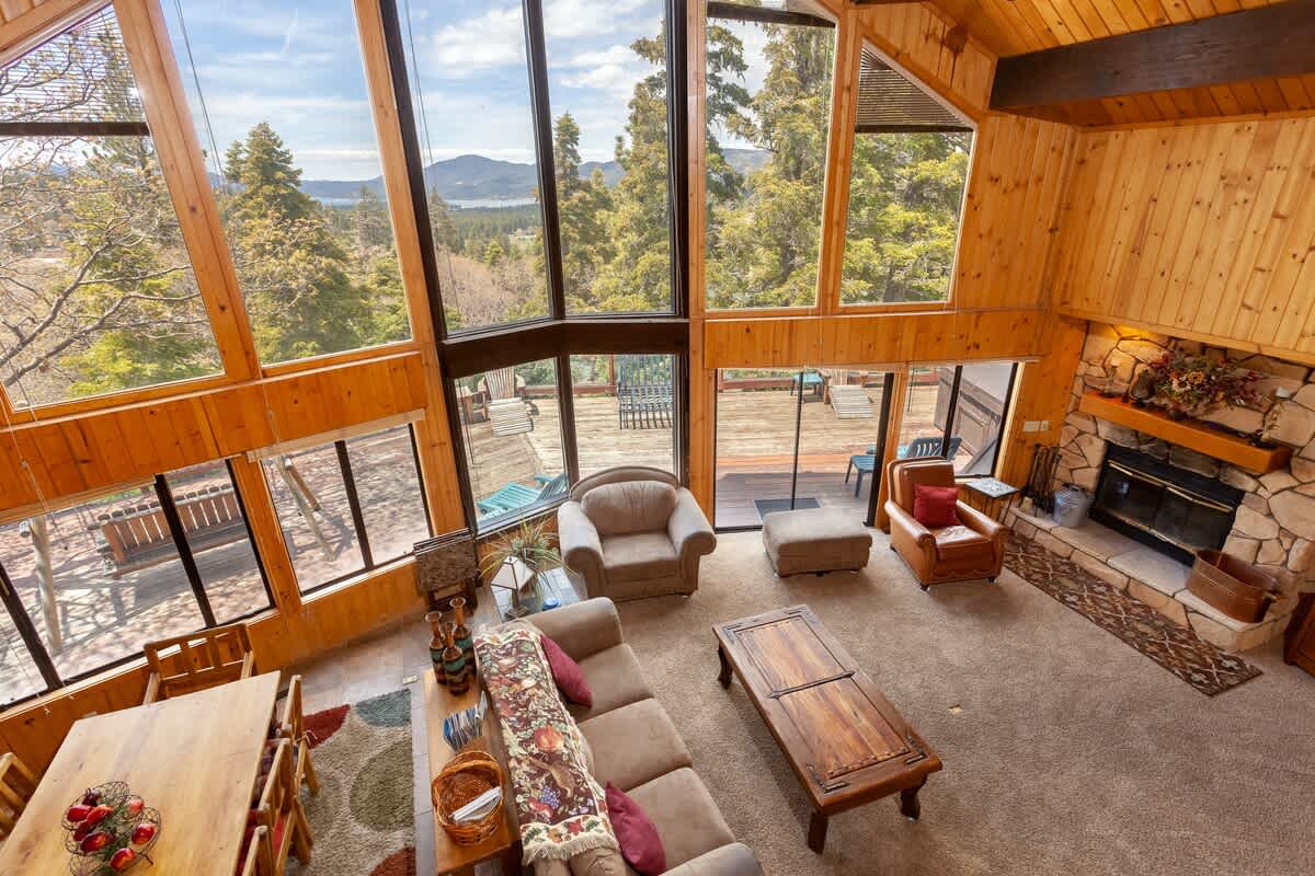 Floor-to-ceiling windows frame the lake and mountain views