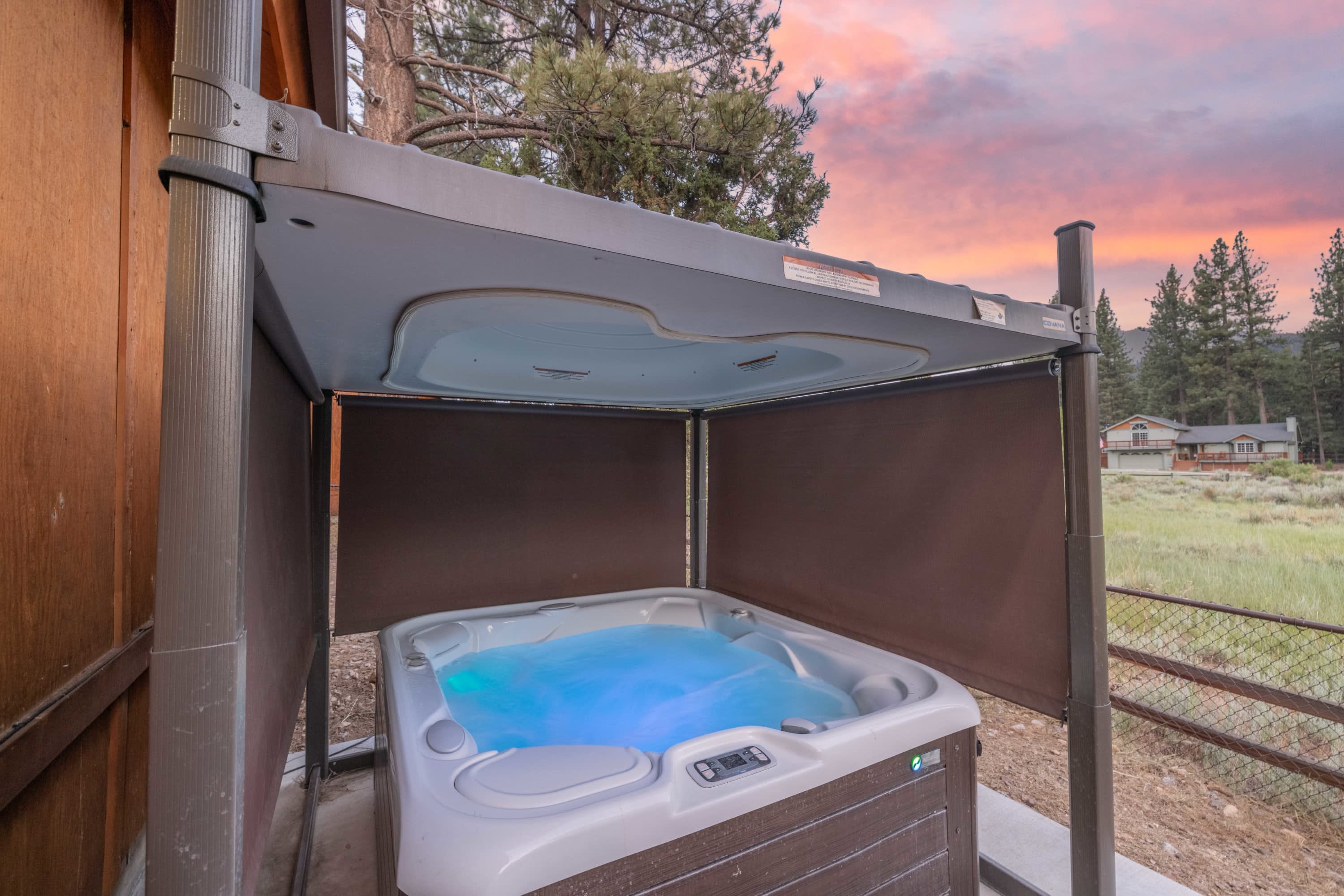 Private LED hot tub with auto-lift cover and privacy curtains