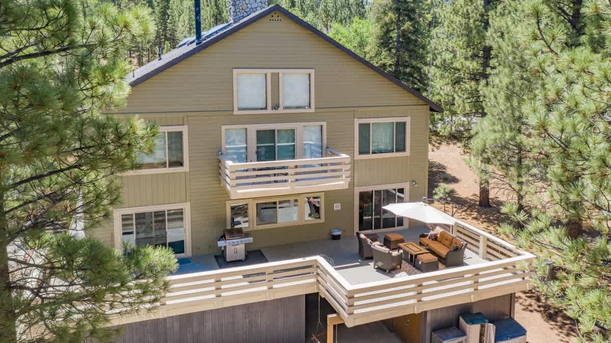 Aerial view of the lodge and wraparound deck among the pines.