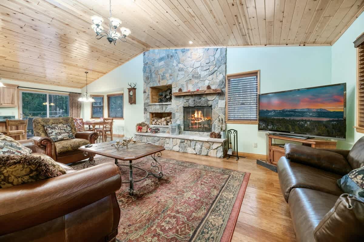 Living room with stone wood-burning fireplace and big TV