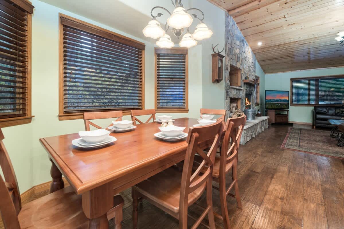 Dining table beside the stone fireplace