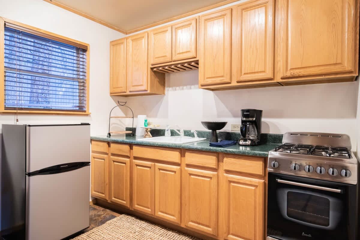 Mini kitchen with fridge, stove and coffee maker