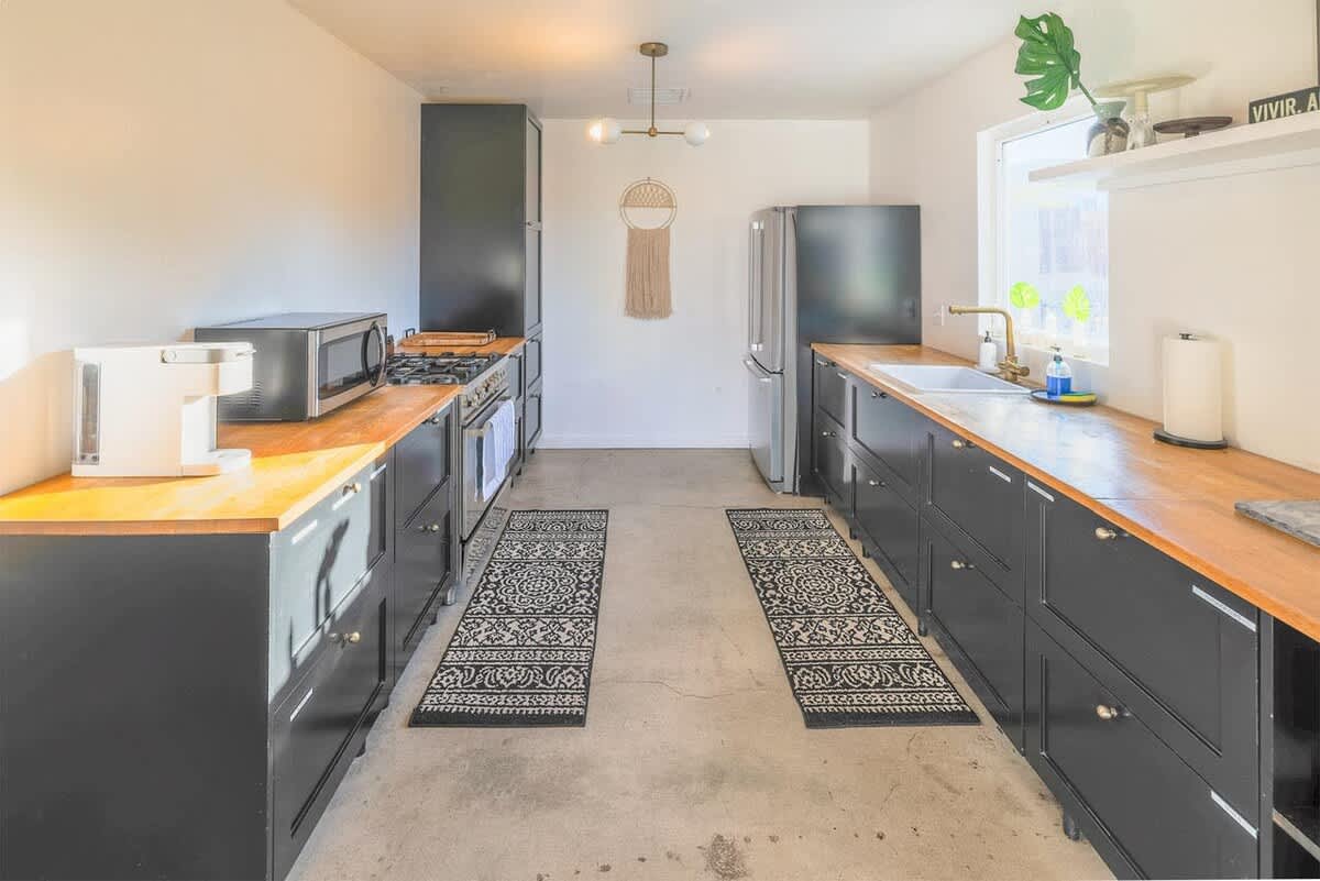 Galley kitchen with stainless appliances and butcher-block counters.