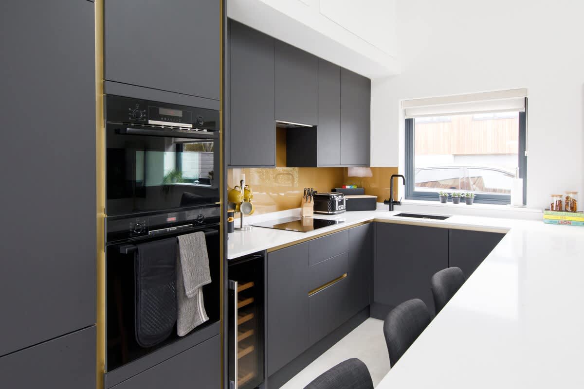 Cedar Lodge: Sleek and modern kitchen with high-end appliances, a wine cooler, and ample counter space. Features stylish dark cabinetry and warm accents, making it fully equipped for preparing meals during your stay in comfort and style.