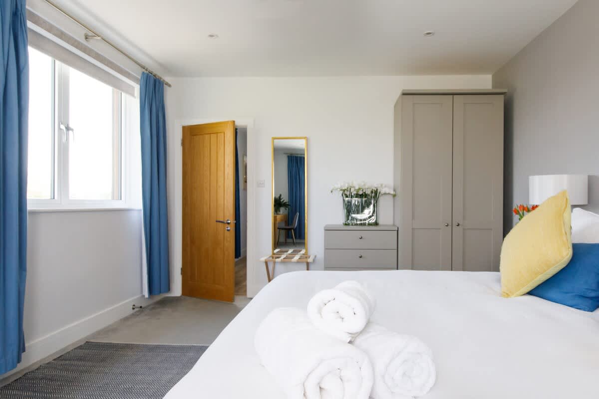 Bedroom 2 - Spacious and serene bedroom featuring a luxurious king-size bed with crisp linens, stylish decor, and ample natural light. Includes a workspace, bedside tables, and scenic views, ensuring a restful and comfortable stay for guests.