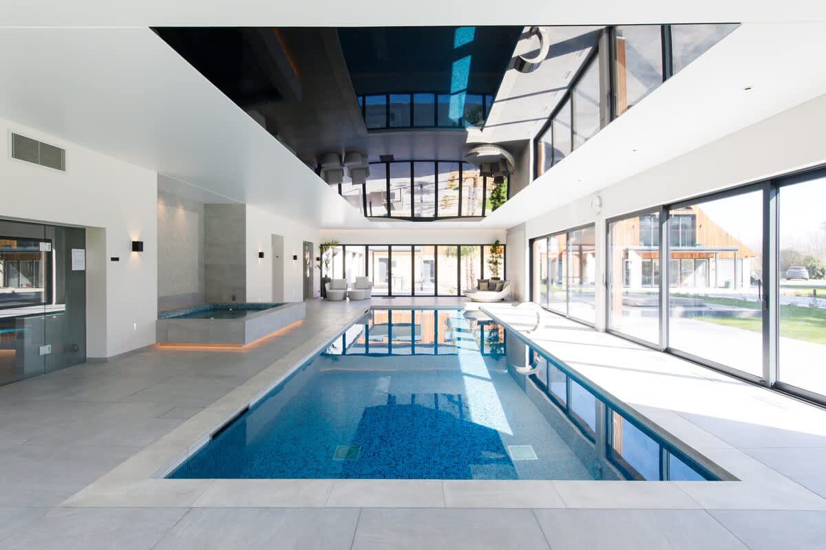 12 metre indoor pool with floor-to-ceiling glass doors, a jacuzzi, & sleek modern design. Flooded with natural light, this luxurious space is perfect for relaxation & enjoying breathtaking views of the surrounding countryside (extra charges apply)