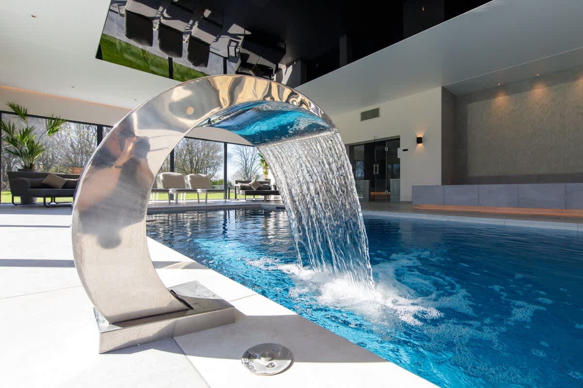 Experience relaxation at The Cedars heated indoor pool, featuring a stunning water cascade and chic design. Perfect for a rejuvenating escape or family fun. Please note: extra charges apply for pool usage