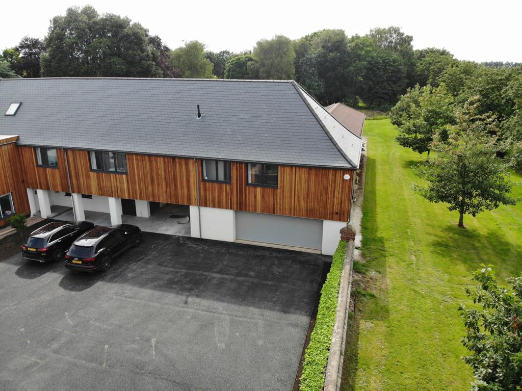 Cedar House - Modern property with ample parking & a sleek wooden exterior, nestled beside lush greenery and open fields. Perfect for a tranquil countryside escape with plenty of space for families & groups to unwind & enjoy the serene surroundings
