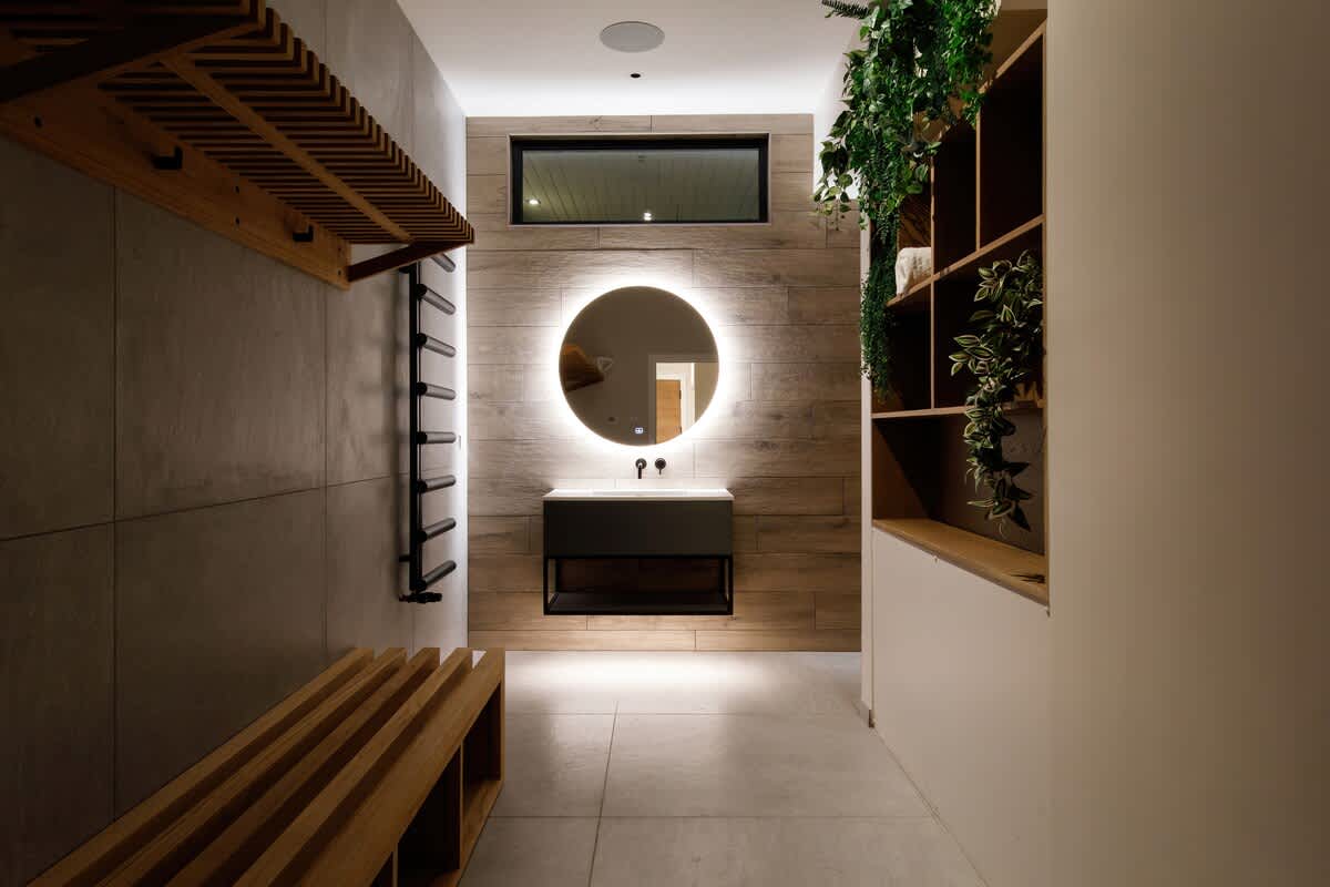 Unwind in The Cedars spa-inspired changing area, featuring ambient lighting, natural wood accents, and lush greenery. Ideal for prepping before or after a swim or sauna session. Please note: extra charges apply for access to wellness facilities.