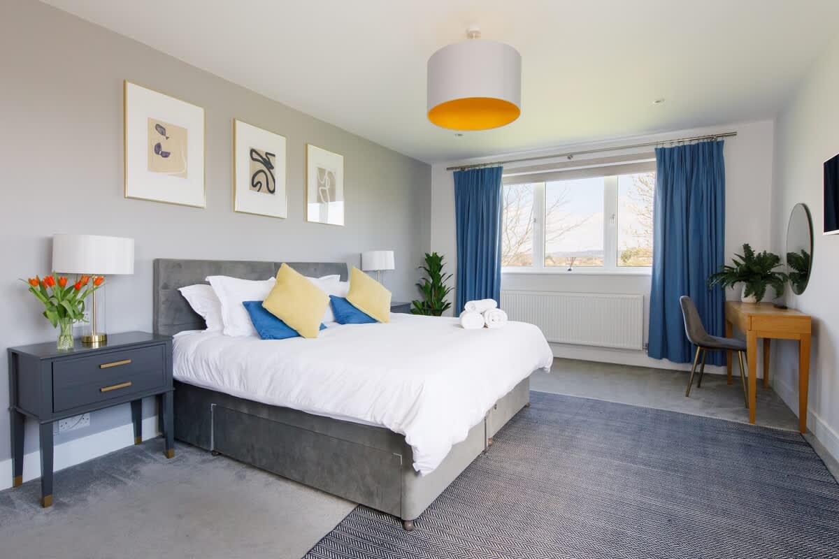 Bedroom 2 - Spacious and serene bedroom featuring a luxurious king-size bed with crisp linens, stylish decor, and ample natural light. Includes a workspace, bedside tables, and scenic views, ensuring a restful and comfortable stay for guests.