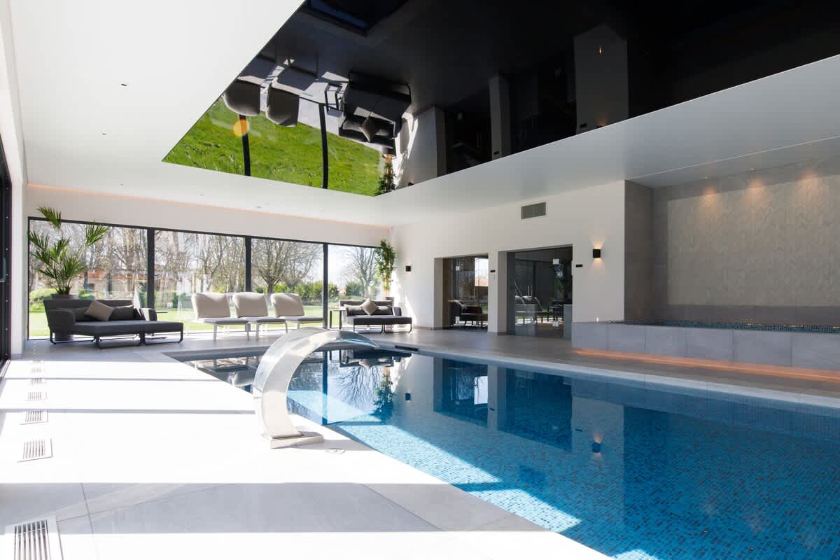 Indulge in luxury at The Cedars heated indoor pool, complete with a sleek water feature, poolside lounge chairs, and serene garden views. A perfect space to unwind or enjoy family time. Please note: extra charges apply for pool usage