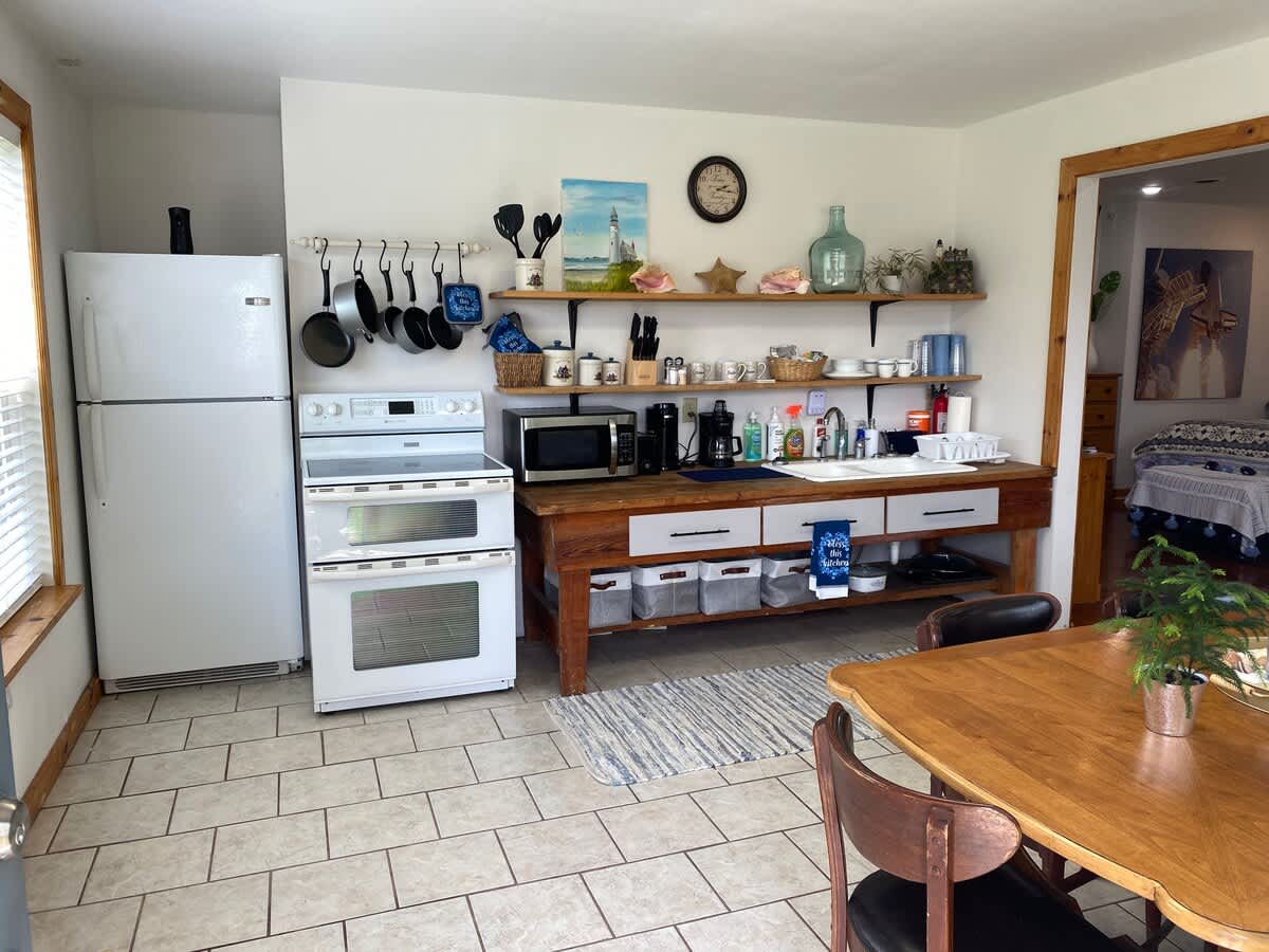 Kitchen with dishes utensils cookware coffee maker, toaster, range/refrigerator/freezer/ice maker, microwave. Large Dining Table & 6 Chairs.
Outdoor patio with natural gas grill, cooking tools, tables & chairs porch swings & fire pit. 
