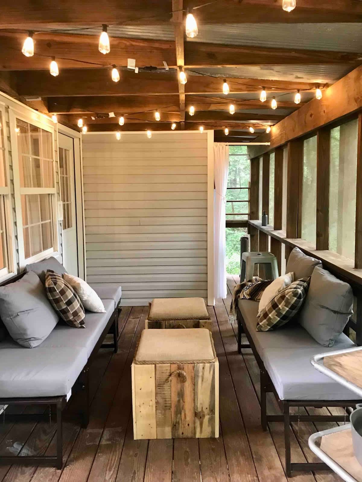 One of two fully screened in porches overlooking the forest. This one is downstairs off the south bedroom. It features an outdoor shower and two day beds.