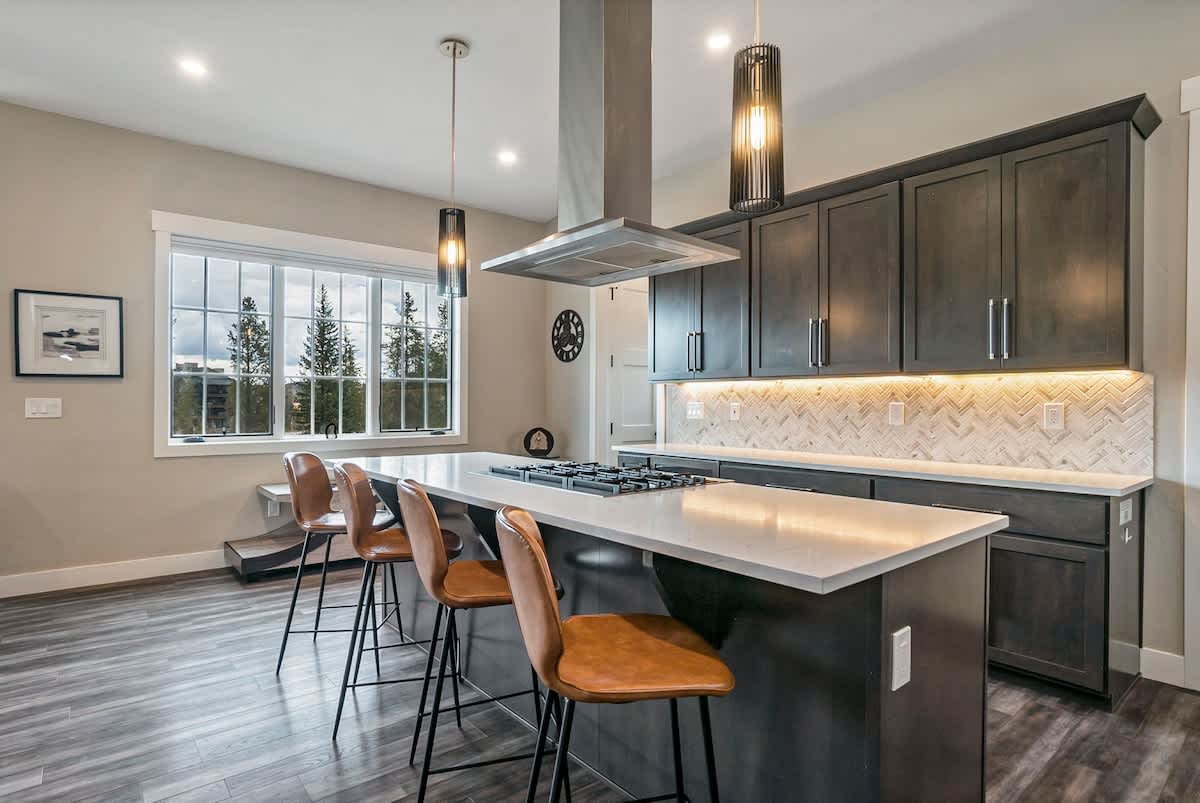 - Wake up to mountain views while sipping coffee at this bright and open kitchen island
- Under cabinet lighting and waterfall quartz counters add both ambiance and style
- Whether cooking or chatting, this space invites everyone in